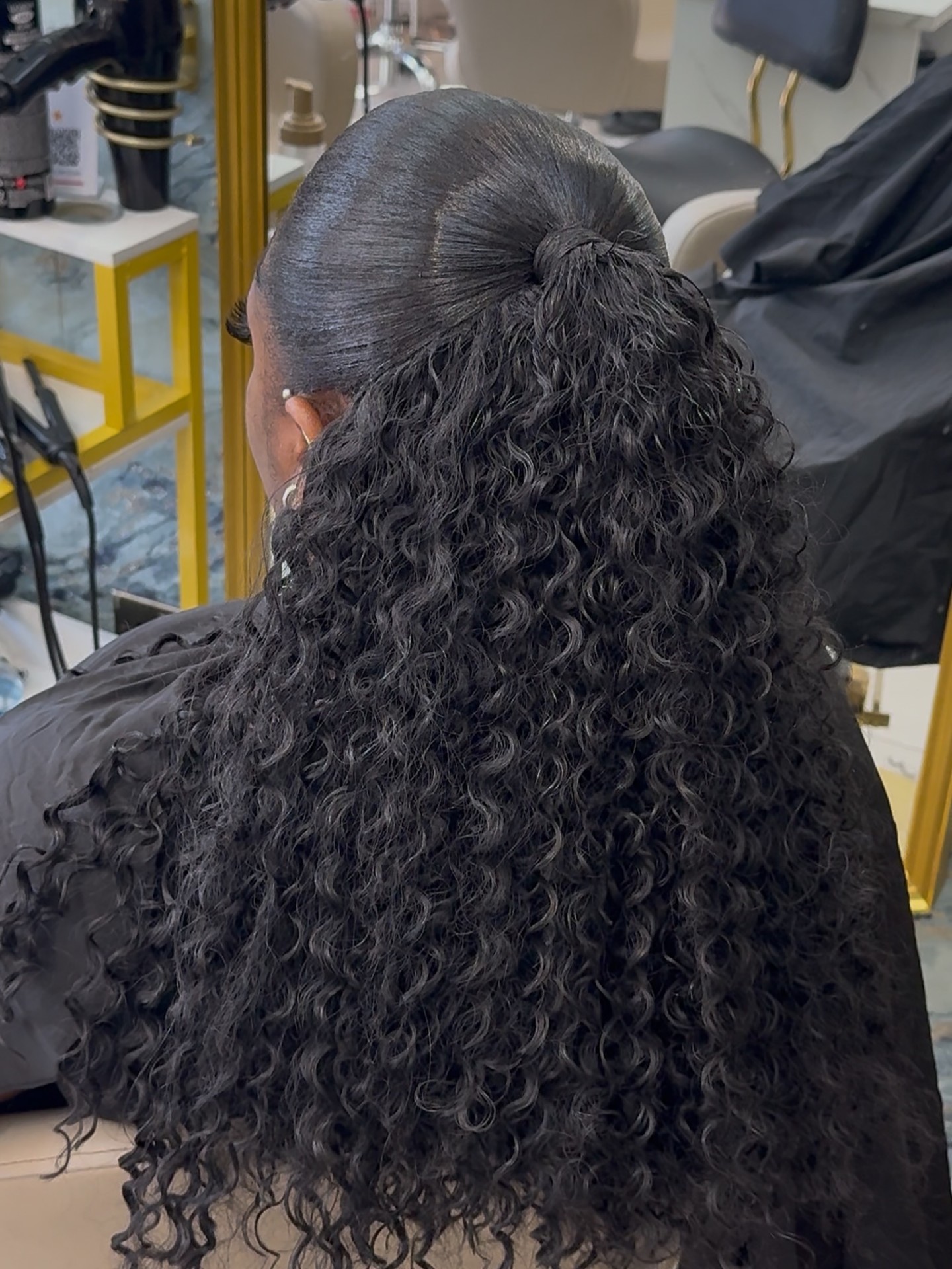 Half-up bun with long curly ponytail